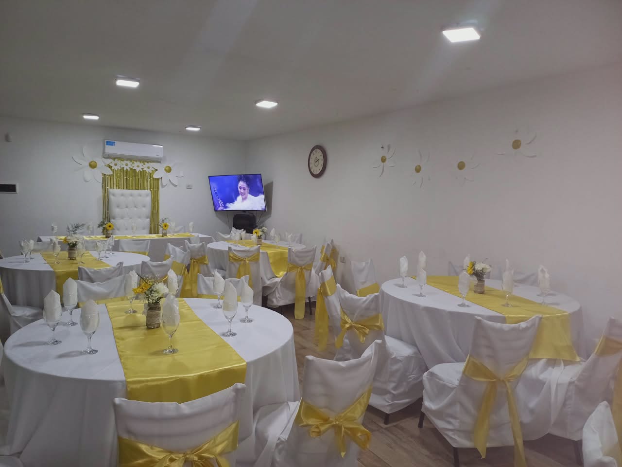 Salón decorado con manteles amarillos y flores de girasol para casamiento