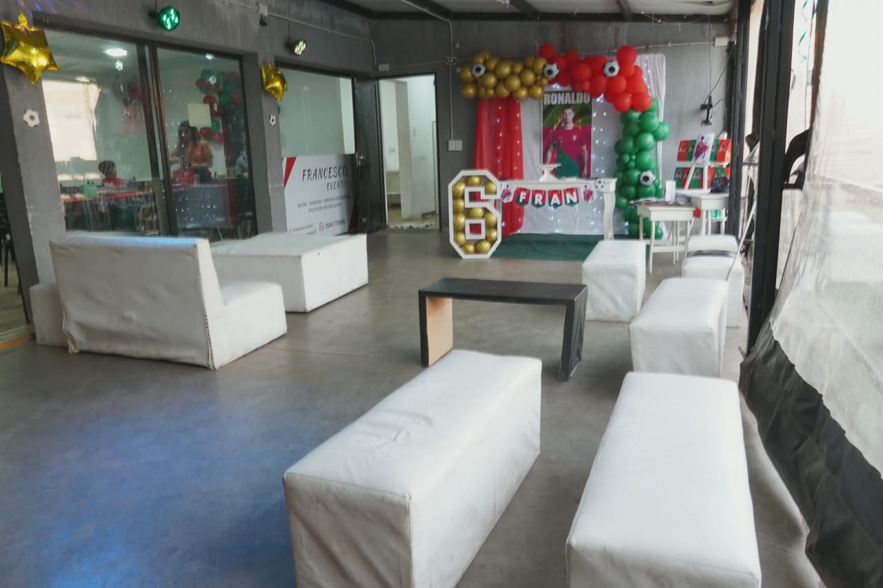 Zona lounge decorada para cumple de 6 años con globos dorados