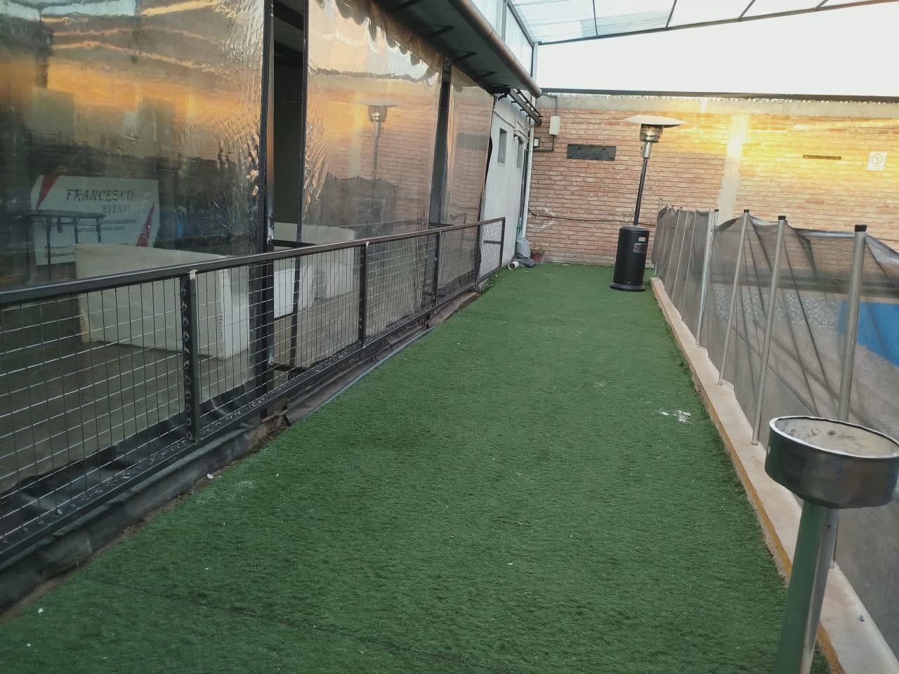 Exterior con césped sintético, calefactores y pileta