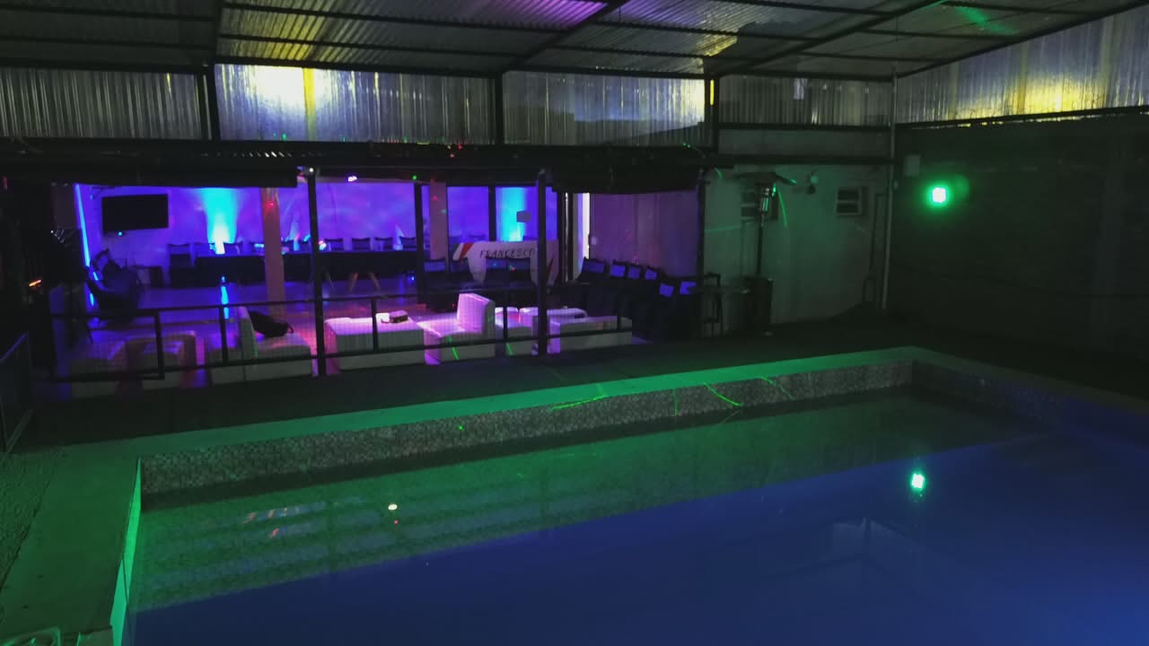 Salón Francesco Eventi con luces violetas, mesas preparadas y globos